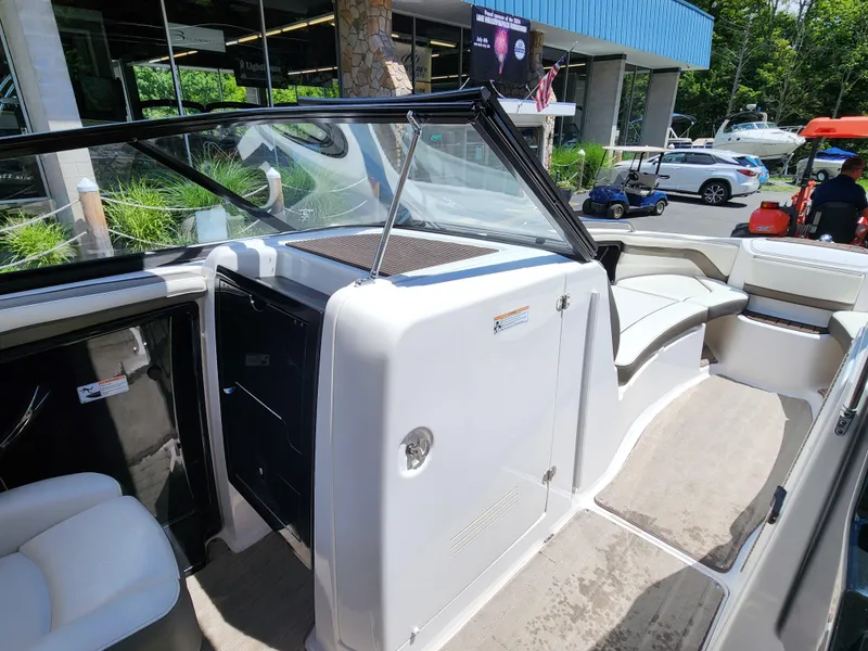 Slide: The Image of 2016 Yamaha Boats 242 Limited S interior with seating and windshield, displayed outdoors. - 26