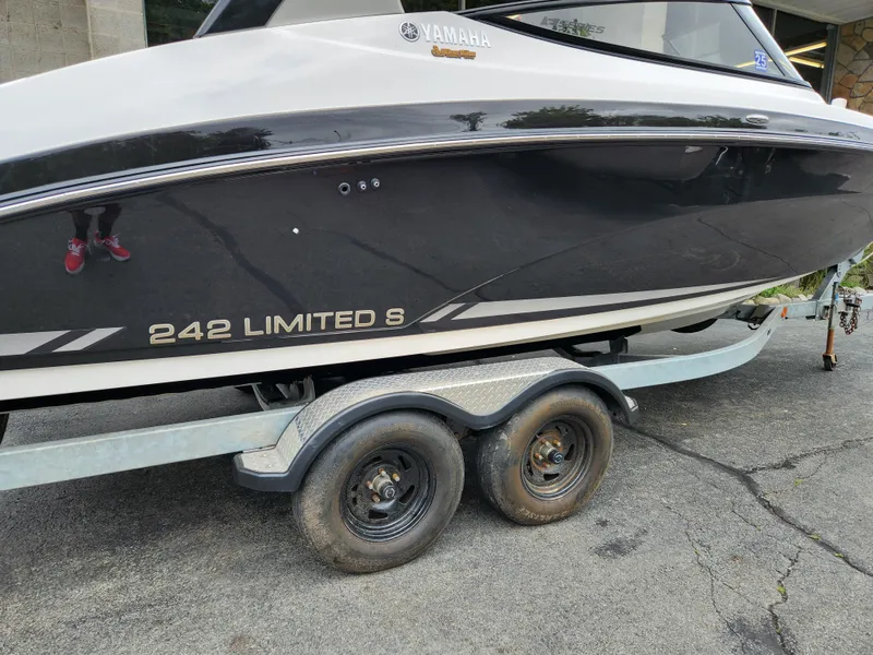 Slide: The Image of 2016 Yamaha Boats 242 Limited S on trailer, black hull, side view. - 8