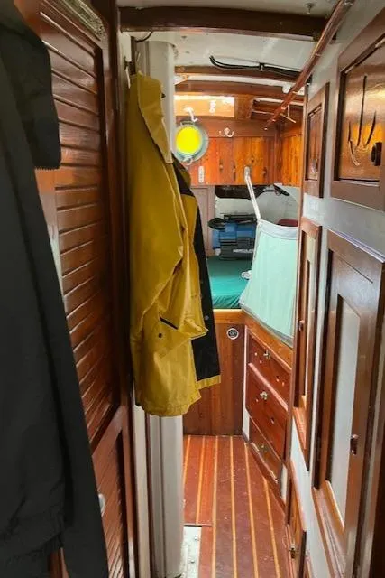 Slide: The Image of Interior of 1986 Alden Malabar Tribute yacht with wooden paneling and yellow raincoat. - 18