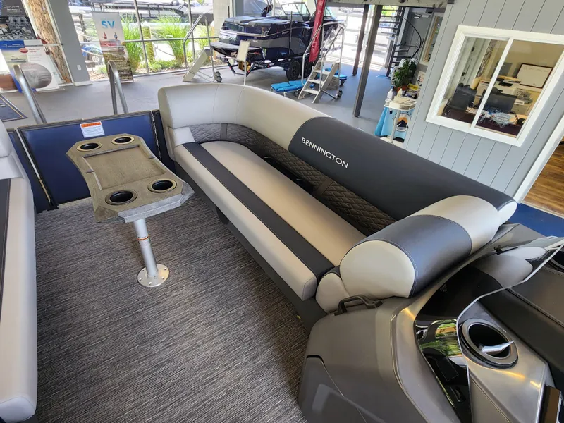 Slide: The Image of 2025 Bennington 22SSR pontoon boat interior with gray seating and cupholder table. - 5