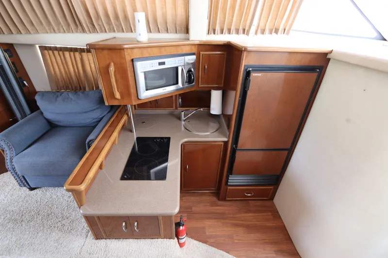 Slide: The Image of 2007 Carver 35 Super Sport yacht kitchen with microwave, stove, and refrigerator. - 26