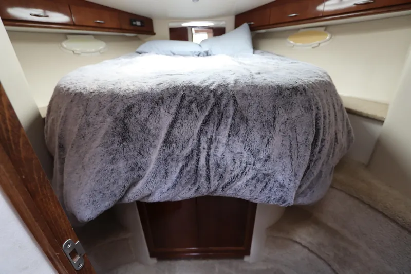 Slide: The Image of 2007 Carver 35 Super Sport boat interior bedroom with cozy bed and wooden cabinets. - 32