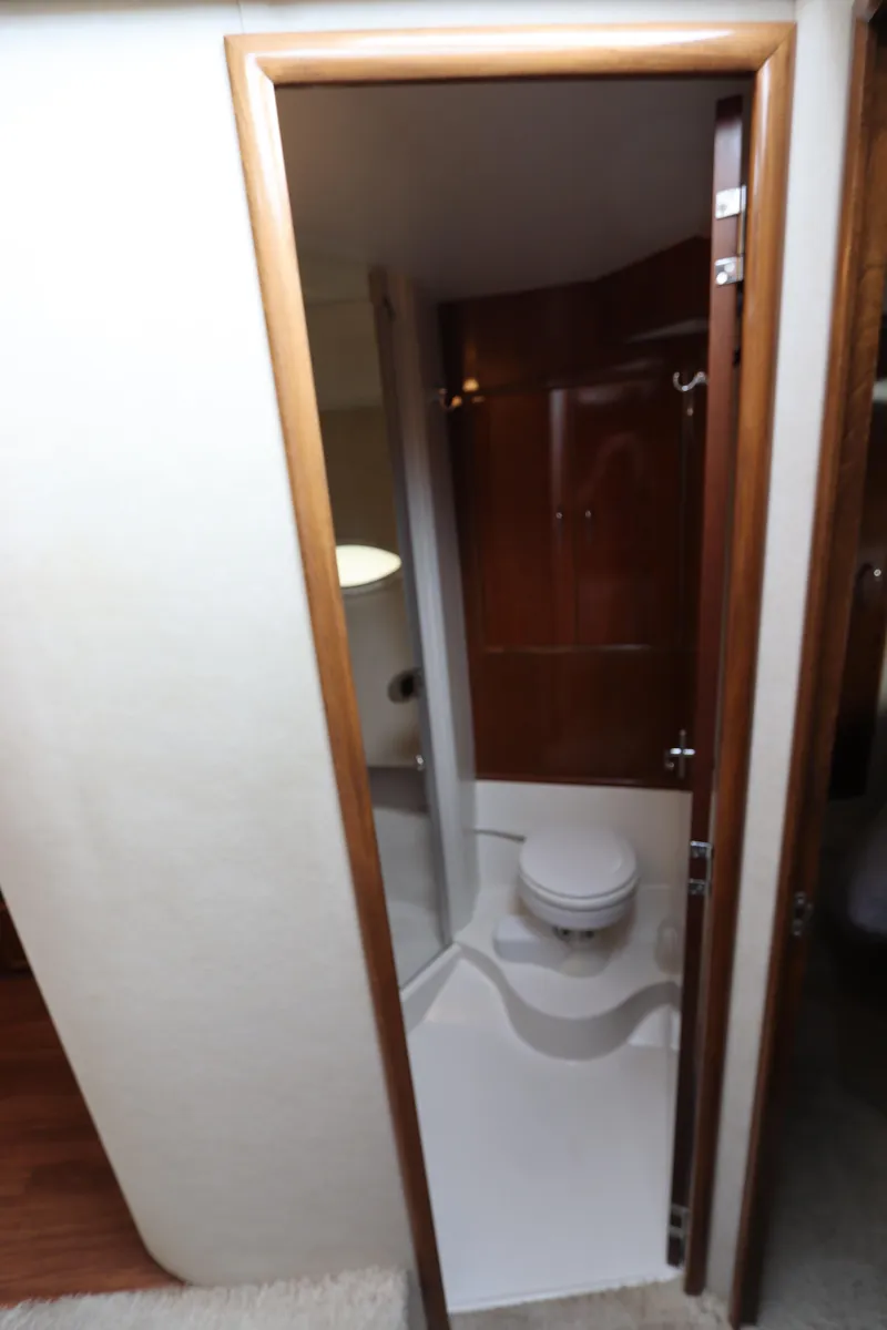 Slide: The Image of 2007 Carver 35 Super Sport yacht bathroom with wooden cabinetry and white fixtures. - 35