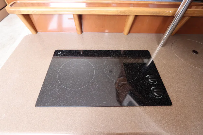 Slide: The Image of 2007 Carver 35 Super Sport glass cooktop in kitchen area. - 27