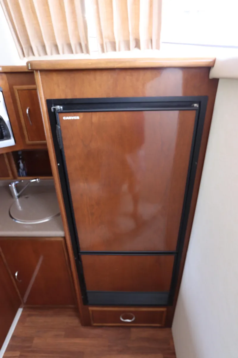 Slide: The Image of 2007 Carver 35 Super Sport galley with wood-paneled refrigerator. - 30