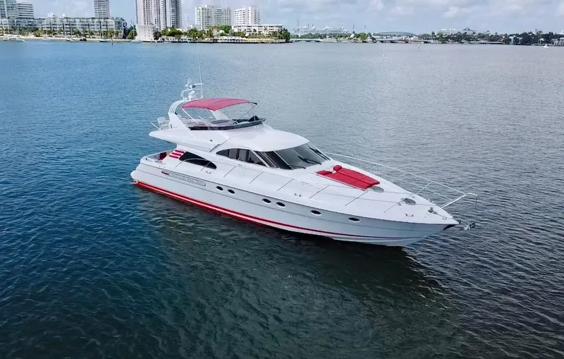 Slide: The Image of 1999 Fairline Squadron 65 luxury yacht on calm waters with city skyline background. - 2