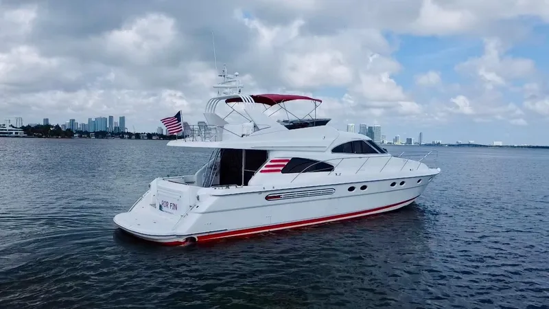 Slide: The Image of 1999 Fairline Squadron 65 yacht on calm waters with city skyline in background. - 4