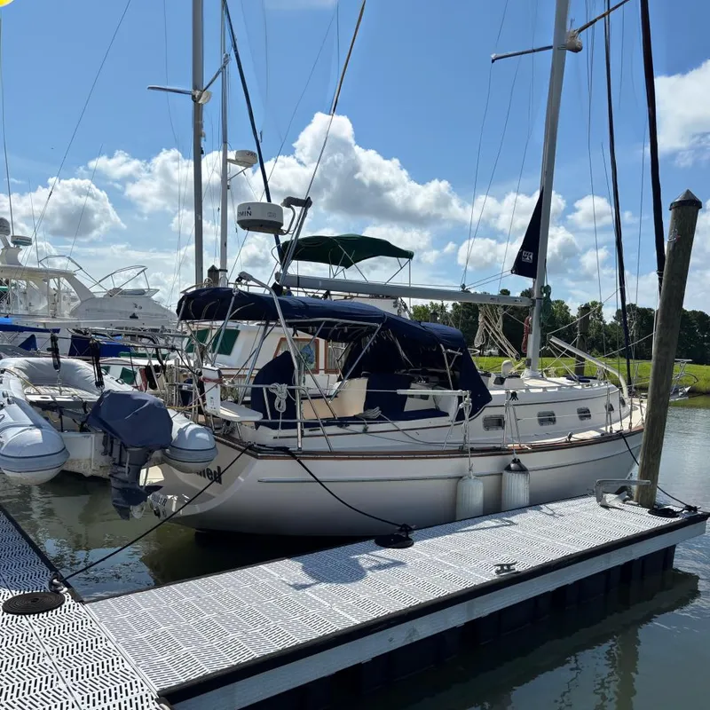 The Image of 1999 Island Packet 350 sailboat docked at marina under clear blue sky. - 0