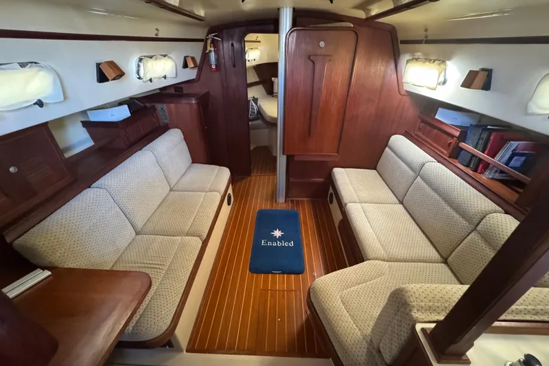 Slide: The Image of 1999 Island Packet 350 yacht interior with cozy seating and wooden finishes. - 12