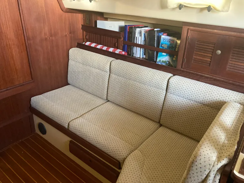 Slide: The Image of Cozy interior of 1999 Island Packet 350 sailboat with cushioned seating and wooden cabinetry. - 14