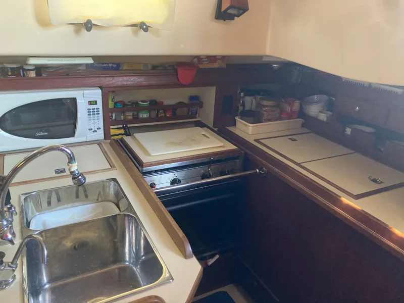 Slide: The Image of 1999 Island Packet 350 yacht kitchen with sink, stove, and microwave. - 19