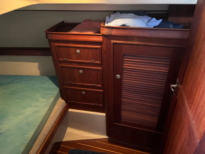 Slide: The Image of Cozy cabin interior of 1999 Island Packet 350 sailboat with wooden storage and bedding. - 24
