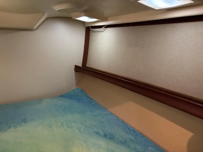 Slide: The Image of Interior cabin of 1999 Island Packet 350 sailboat with blue bedding and wooden trim. - 25