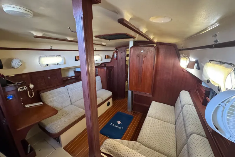 Slide: The Image of Interior of 1999 Island Packet 350 sailboat with cozy seating and wooden finishes. - 26