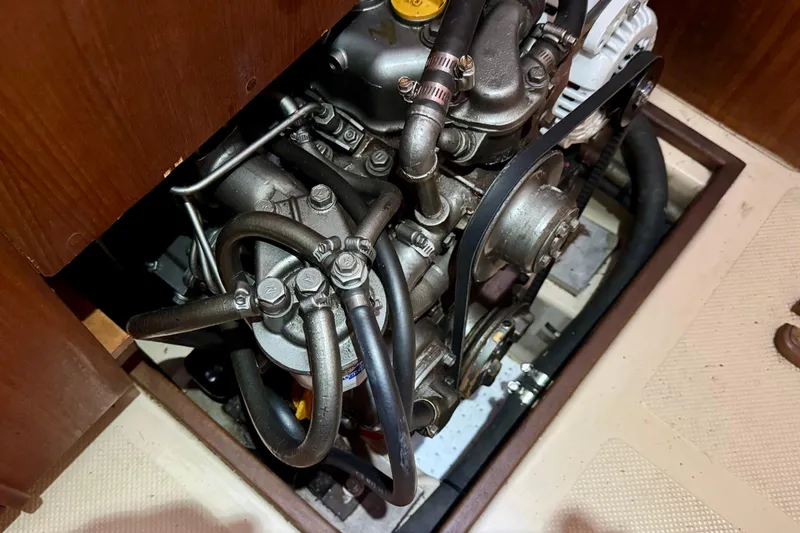 Slide: The Image of Engine compartment of a 1999 Island Packet 350 sailboat, showing detailed mechanical components. - 28