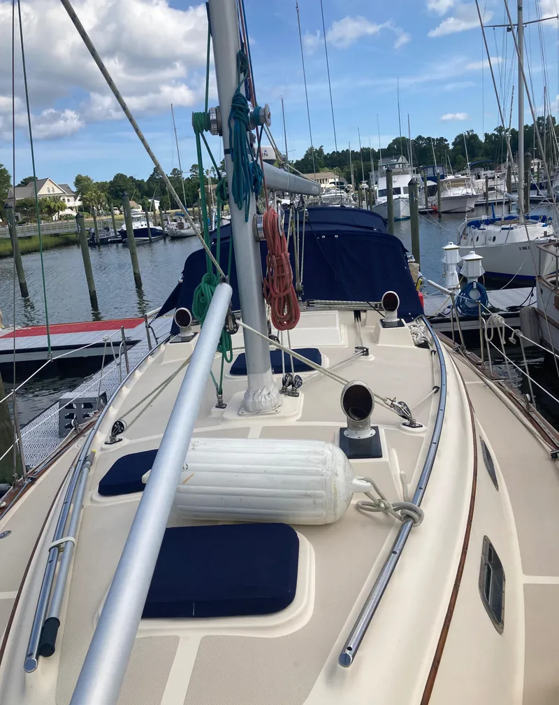 Slide: The Image of 1999 Island Packet 350 sailboat docked at marina, clear sky, calm water. - 3