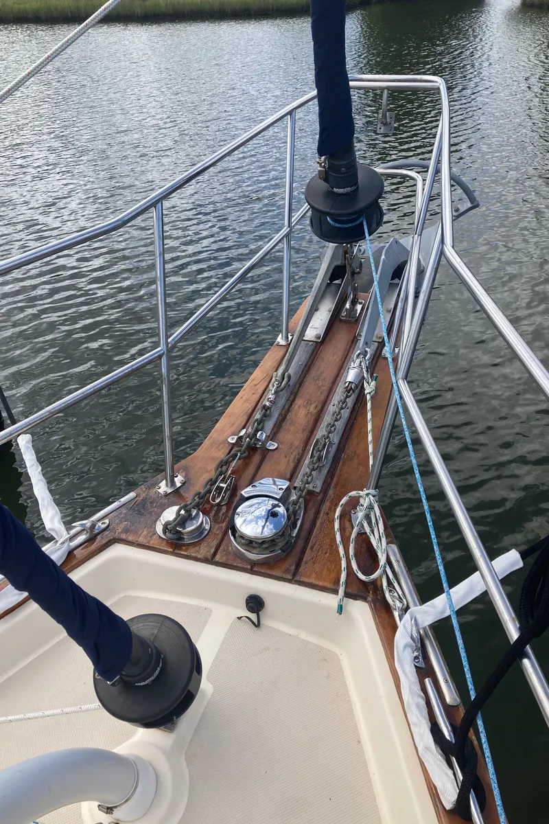 Slide: The Image of 1999 Island Packet 350 sailboat bow with anchor and railing on calm water. - 5