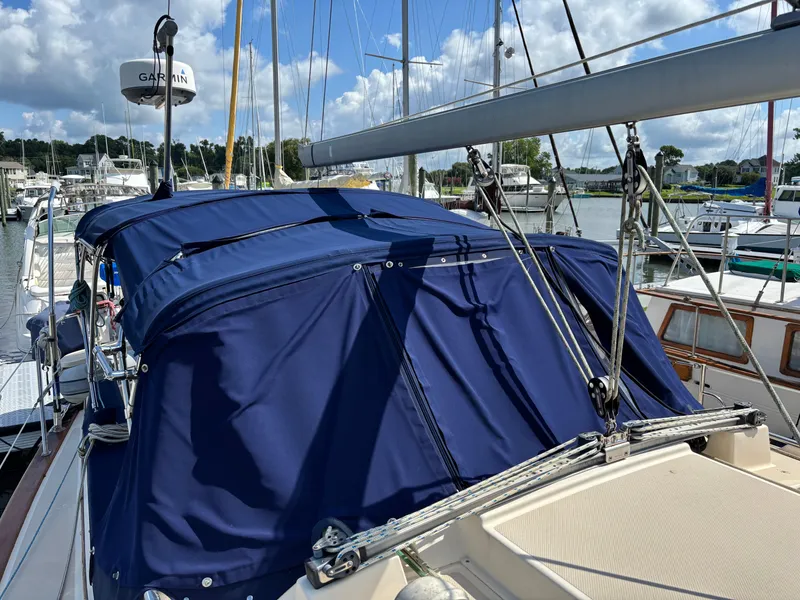 Slide: The Image of 1999 Island Packet 350 sailboat with blue canvas cover docked at marina. - 8