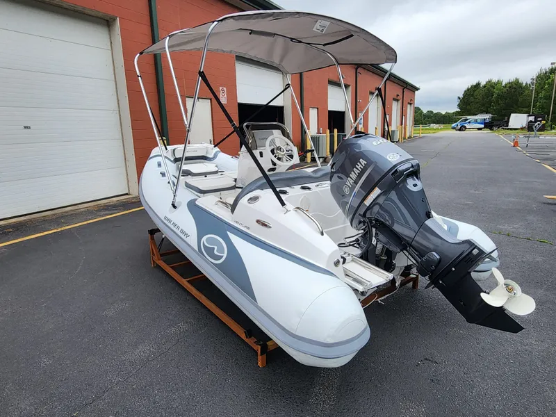 Slide: The Image of 2025 Walker Bay Venture 13 boat with Yamaha outboard motor in a parking lot. - 2