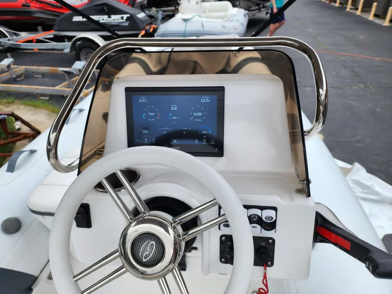 Slide: The Image of Walker Bay Venture 13 2025 boat dashboard with steering wheel and digital display. - 3
