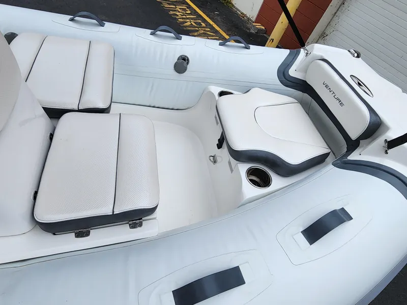 Slide: The Image of Walker Bay Venture 13 inflatable boat interior, 2025 model, featuring cushioned seating. - 7