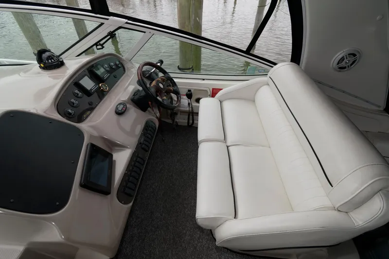Slide: The Image of 2004 Cruisers Yachts 370 Express helm with white seating and control panel. - 4