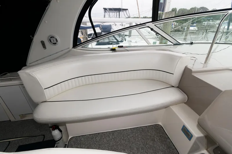 Slide: The Image of 2004 Cruisers Yachts 370 Express interior seating area with white upholstery. - 6