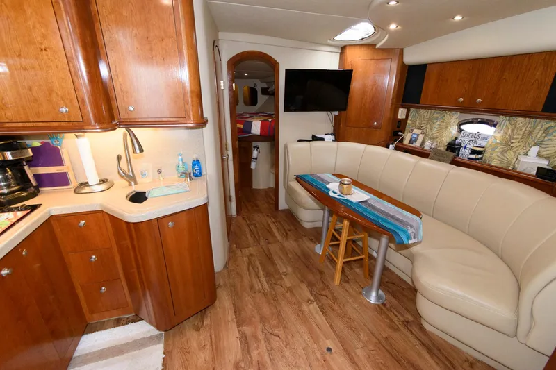 Slide: The Image of 2004 Cruisers Yachts 370 Express interior with kitchen, dining area, and TV. - 9