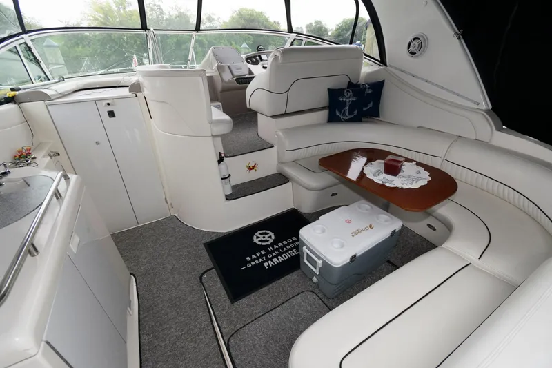 Slide: The Image of Interior of 2004 Cruisers Yachts 370 Express with white seating and wooden table. - 1