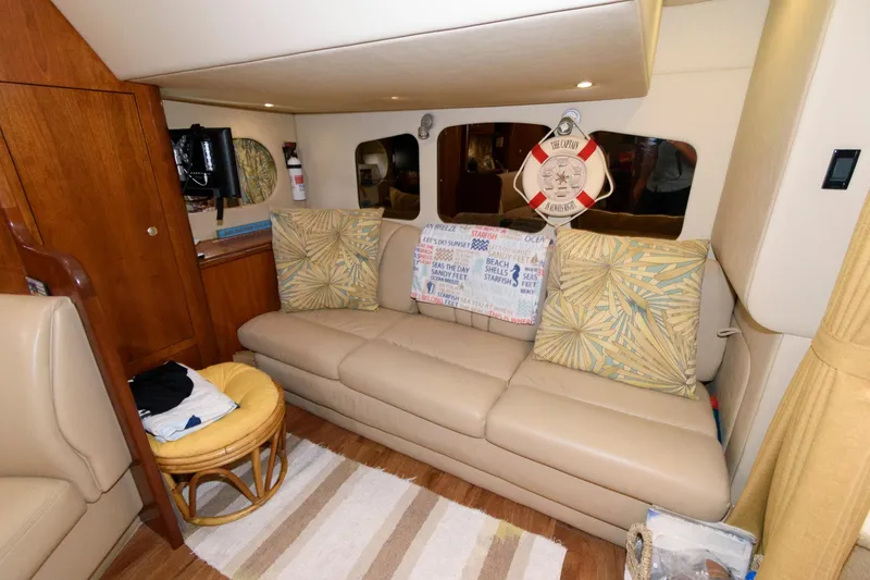 Slide: The Image of Interior of 2004 Cruisers Yachts 370 Express with beige leather sofa and nautical decor. - 13