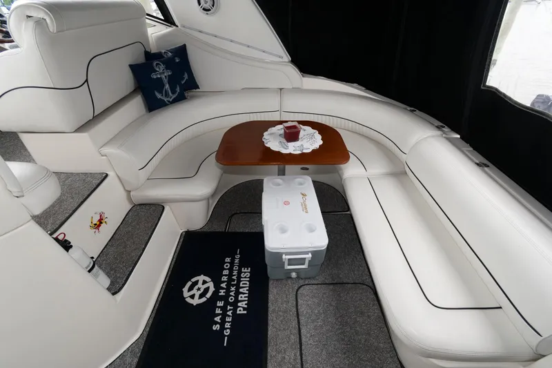 Slide: The Image of 2004 Cruisers Yachts 370 Express interior with white seating and wooden table. - 2