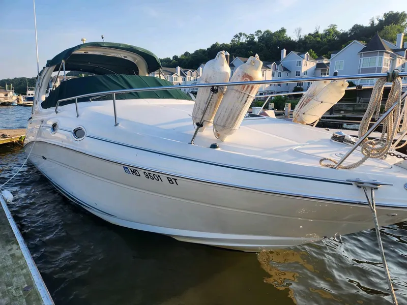 Slide: The Image of 2004 Sea Ray 280 Sundancer docked at a marina with waterfront homes in the background. - 1