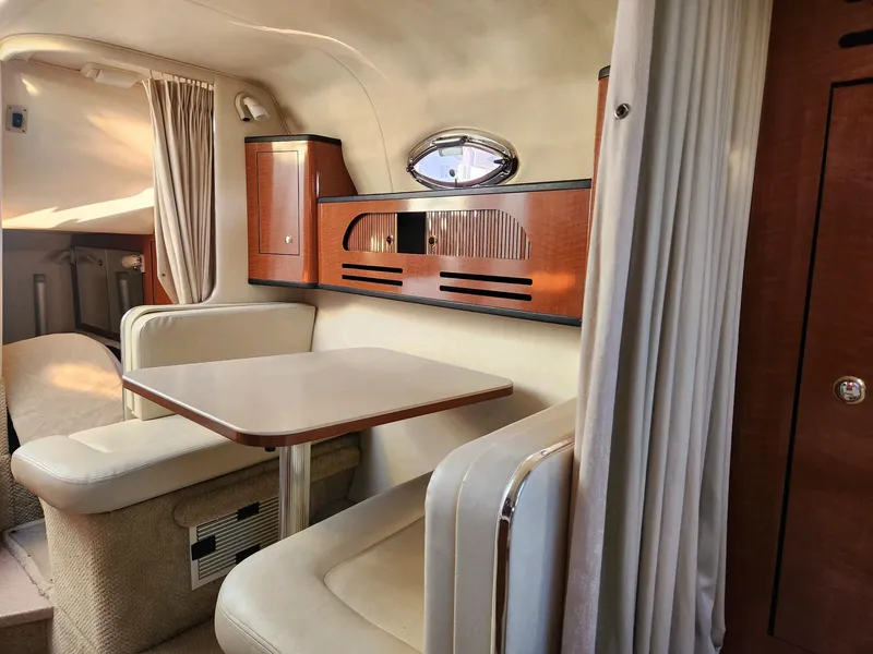 Slide: The Image of Interior of 2004 Sea Ray 280 Sundancer with dining area and wooden cabinetry. - 10