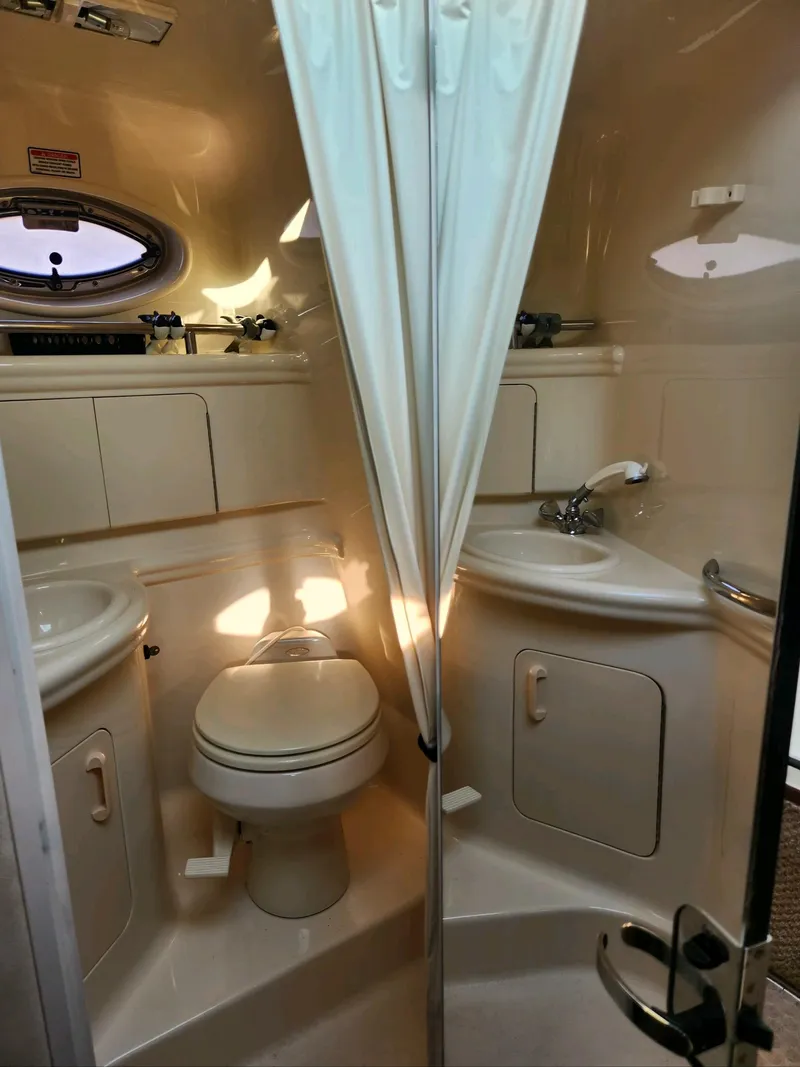 Slide: The Image of 2004 Sea Ray 280 Sundancer bathroom with toilet, sink, and shower. - 12