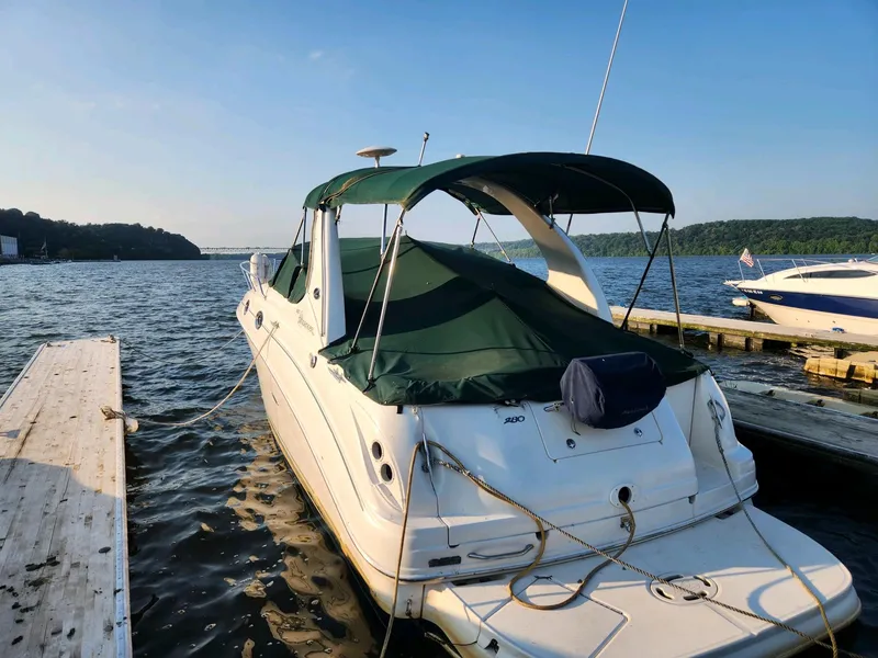 Slide: The Image of 2004 Sea Ray 280 Sundancer docked at a marina on a sunny day. - 2