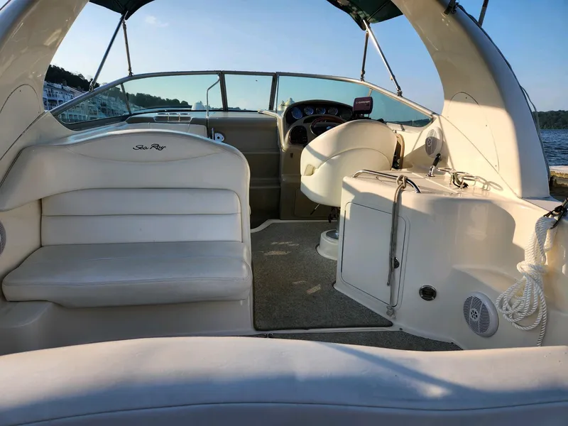 Slide: The Image of 2004 Sea Ray 280 Sundancer boat interior with white seating and helm station. - 3