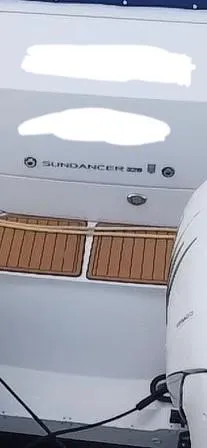 Slide: The Image of 2020 Sea Ray Sundancer 320 OB boat stern with teak flooring and outboard motor. - 19