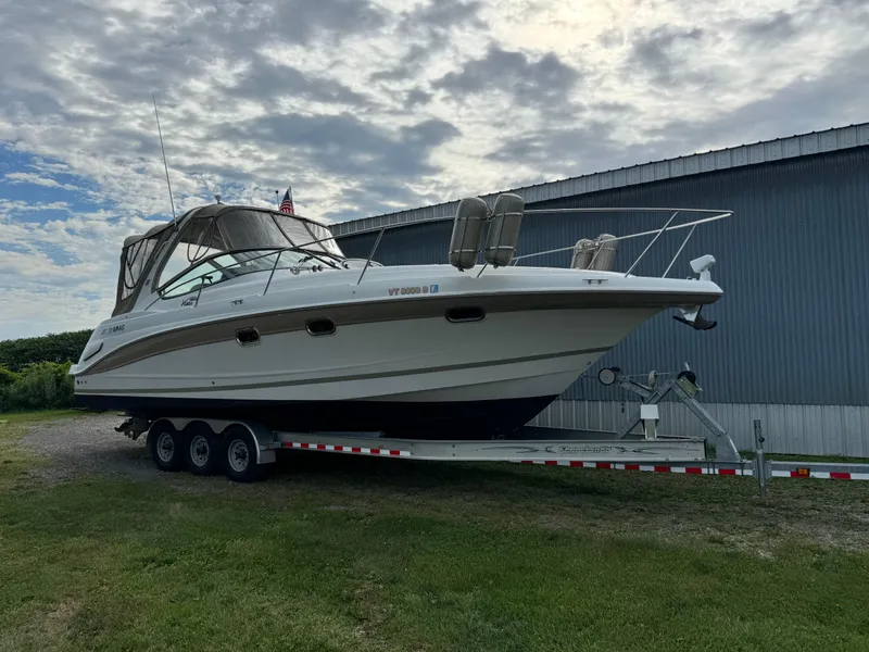 The Image of 2005 Four Winns 328 Vista boat on trailer, parked outdoors near a building. - 0
