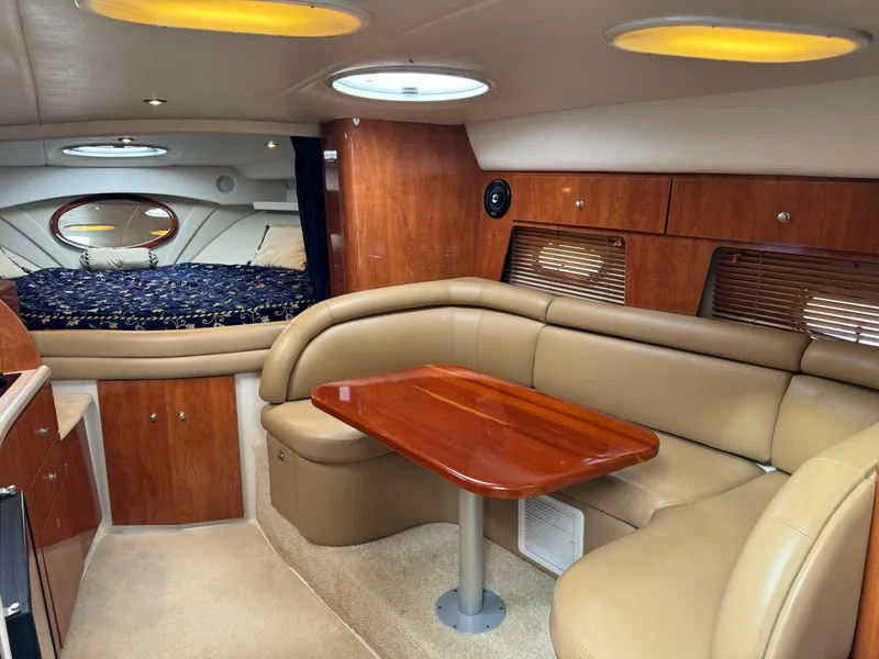 Slide: The Image of 2005 Four Winns 328 Vista cabin interior with leather seating and wooden table. - 17