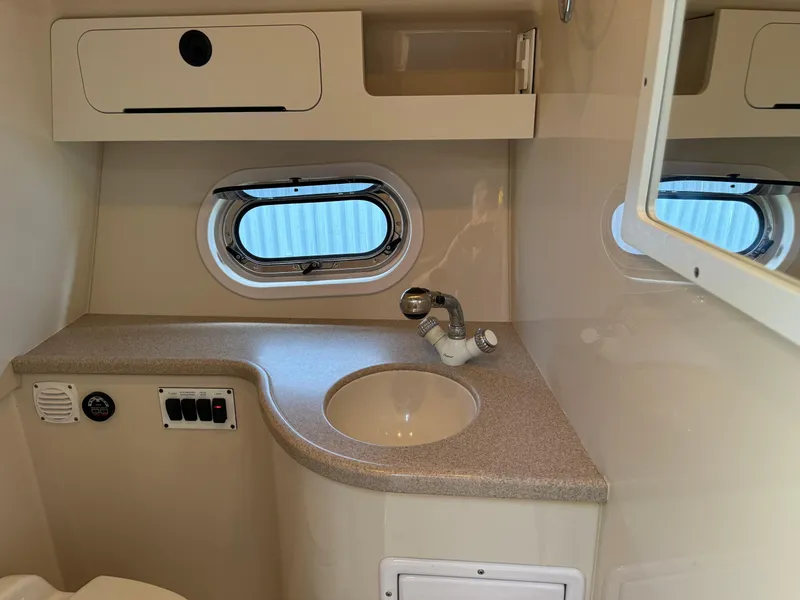 Slide: The Image of 2005 Four Winns 328 Vista boat bathroom with sink, faucet, and porthole window. - 25