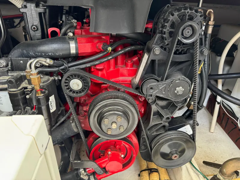 Slide: The Image of Engine compartment of a 2005 Four Winns 328 Vista boat, featuring belts and pulleys. - 26