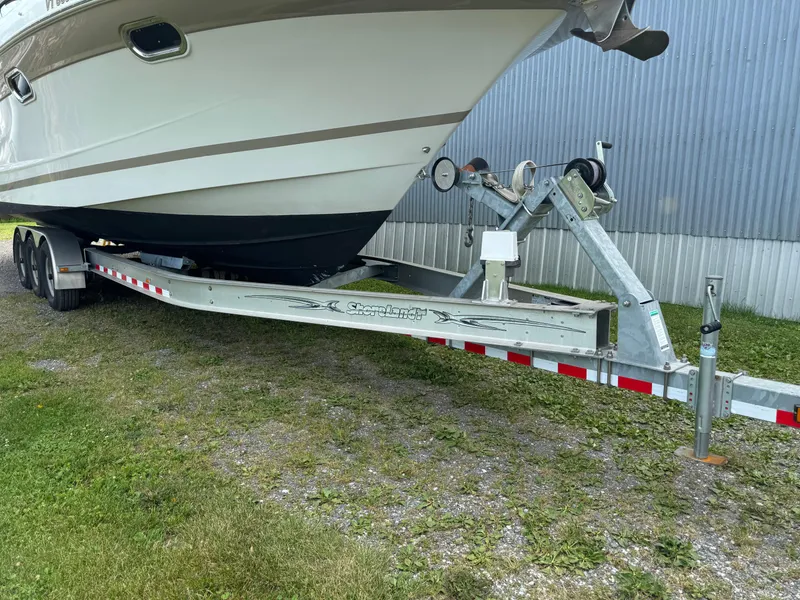Slide: The Image of 2005 Four Winns 328 Vista boat on a trailer, parked on grass. - 34