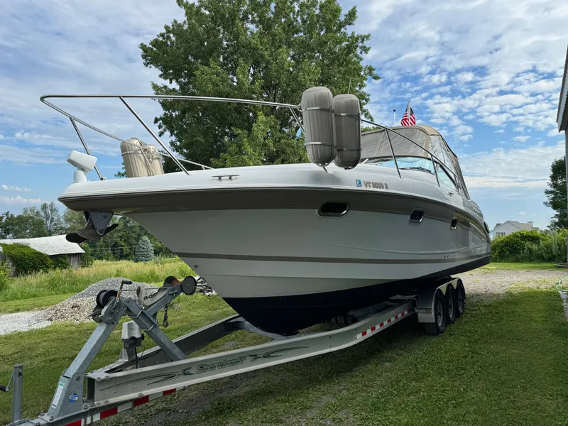 Slide: The Image of 2005 Four Winns 328 Vista boat on trailer, parked outdoors under a partly cloudy sky. - 4