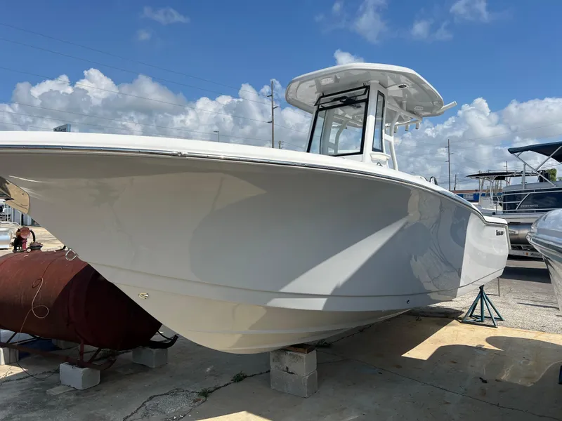 Slide: The Image of 2024 Tidewater 232 CC Adventure boat on display under a clear blue sky. - 4
