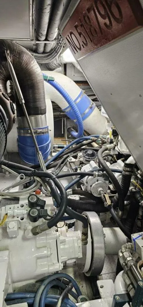Slide: The Image of Engine room of 1969 Derecktor 68 Hunt Motor Yacht, featuring complex machinery and hoses. - 25
