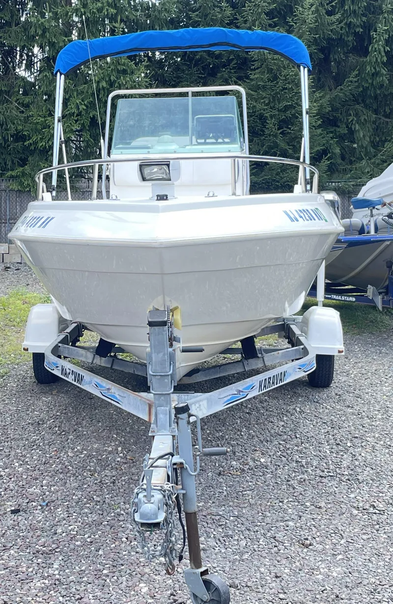 Slide: The Image of 1999 Campion Explorer 582 boat with blue canopy on trailer. - 3