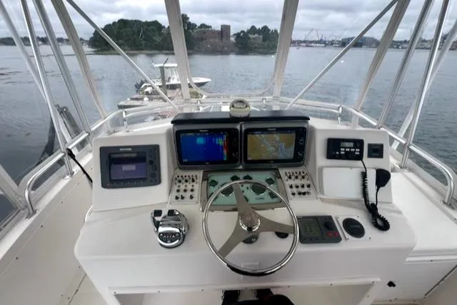 Slide: The Image of 2002 Cabo 35 Flybridge helm with navigation equipment and steering wheel. - 11