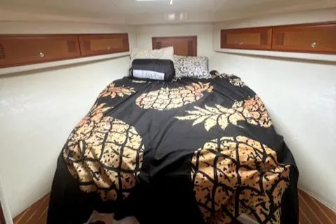 Slide: The Image of 2002 Cabo 35 Flybridge cabin with pineapple-themed bedding. - 14