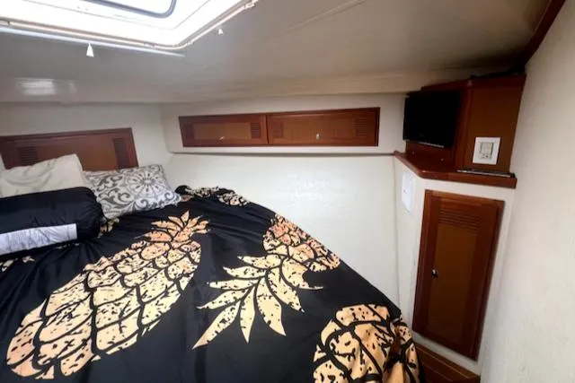 Slide: The Image of 2002 Cabo 35 Flybridge cabin with bed, storage cabinets, and TV. - 15