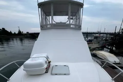 Slide: The Image of 2002 Cabo 35 Flybridge boat docked at marina, front view. - 31